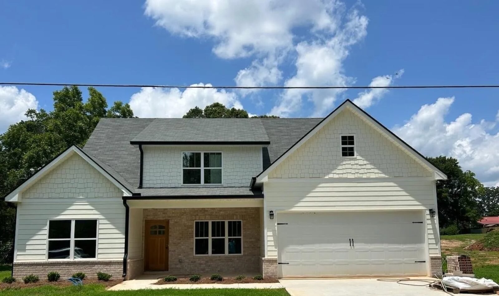 Board-and-batten and brick two-story custom home with covered front porch.